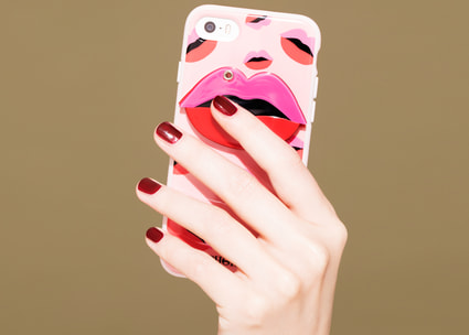 La mano di una donna tiene in mano uno smartphone con disegno delle labbra La mano di una donna tiene in mano uno smartphone con disegno delle labbra